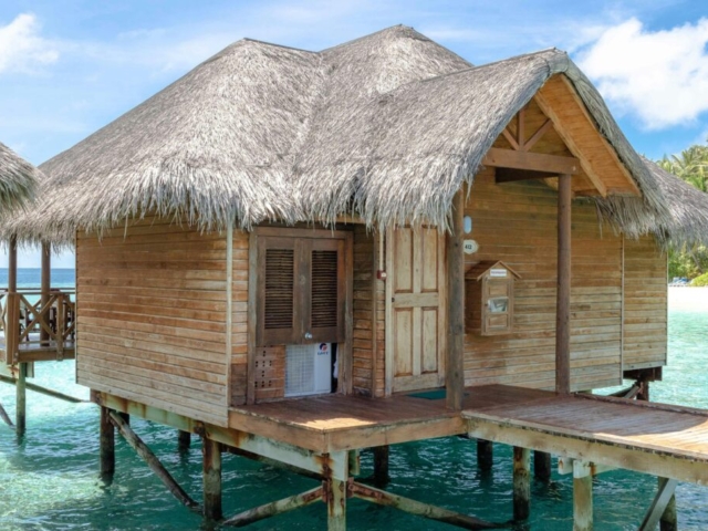 pexels-photo-9394268-9394268 A scenic overwater bungalow with a thatched roof on a tropical Maldives island.